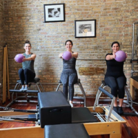 group of ladies in a group reformer class